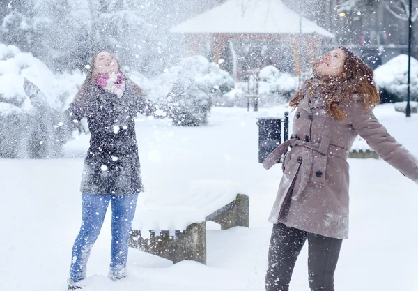 Three teenage girls throwing snow in the air