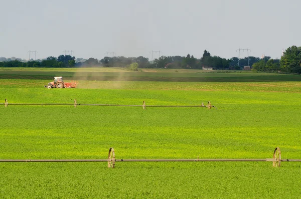 Tractor working on the agricultural field on sunny summer day