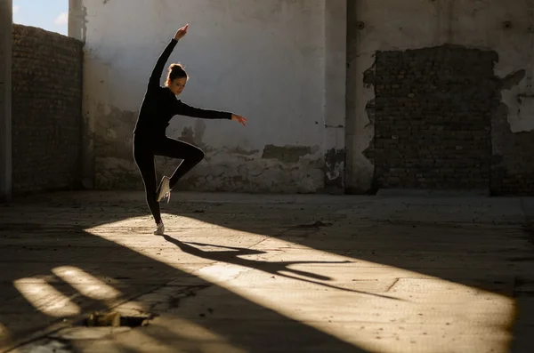 Young modern dancer exercising and dancing in abandoned building