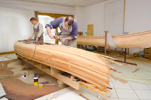 Young carpenters assembling new canoe of their own design