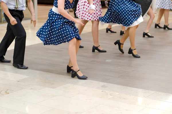 Dance group in vintage clothes dancing on marble floor