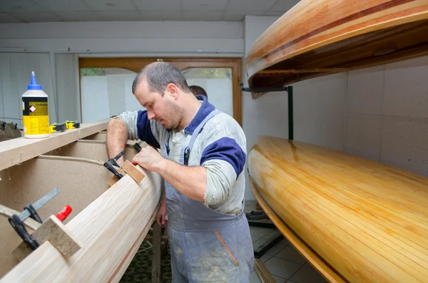 Young carpenters assembling new canoe of their own design