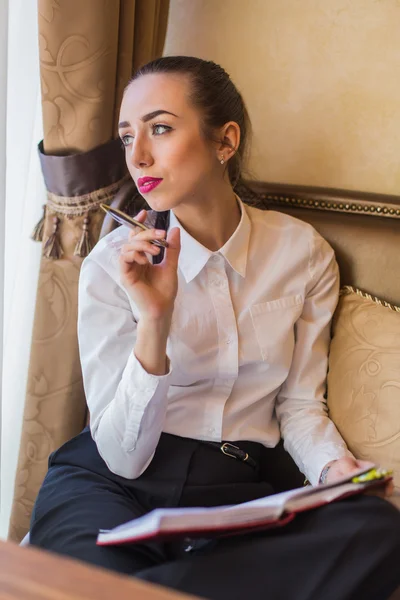 Portrait of young business woman with notebook.