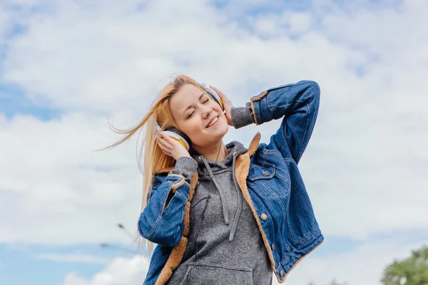 Girl listening to music streaming with headphones.