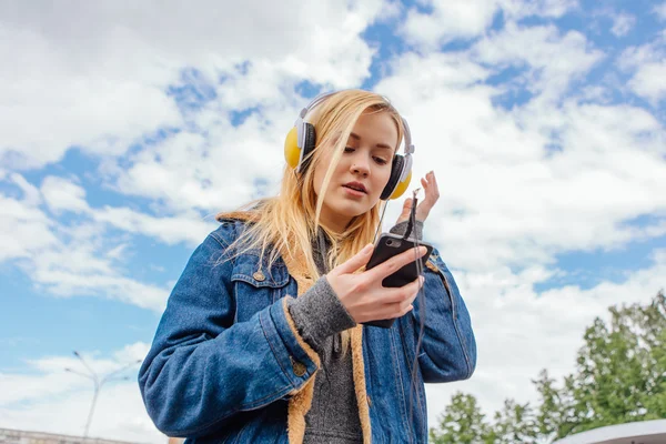 Girl listening to music streaming with headphones.