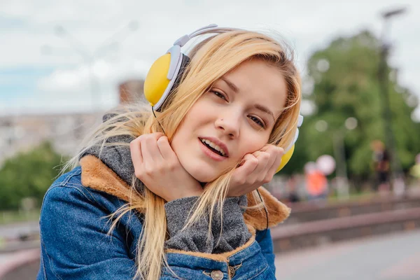 Girl listening to music streaming with headphones.