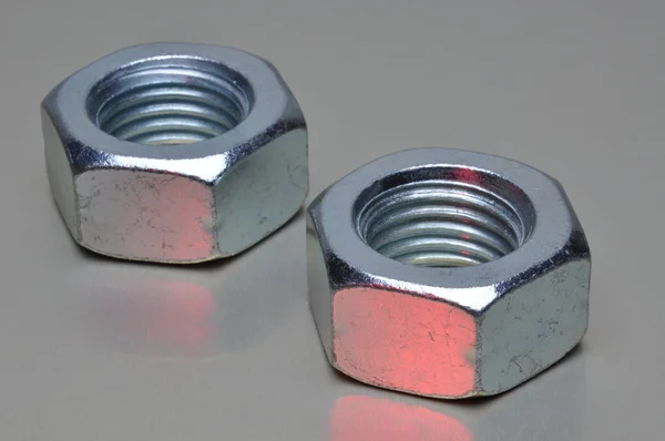 Steel nuts with red light reflection