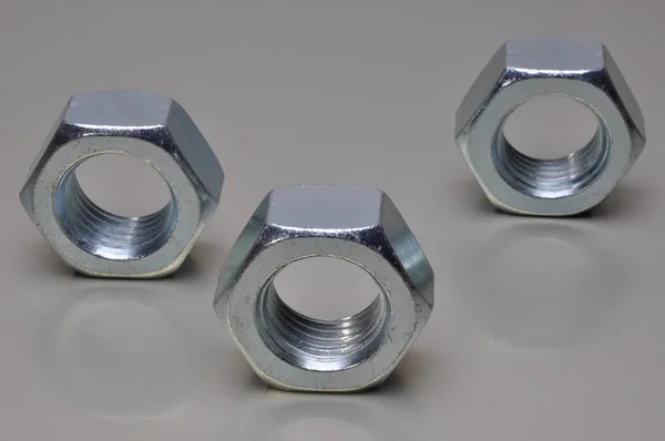 Group of steel nuts with light reflection