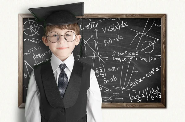 Boy near blackboard with formulas