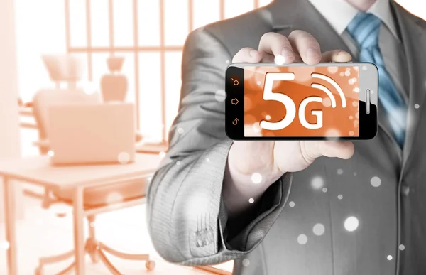 Businessman holding phone with 5G