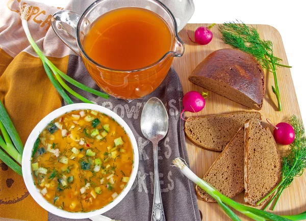 Traditional russian cold soup okroshka, jug of kvass and bread.