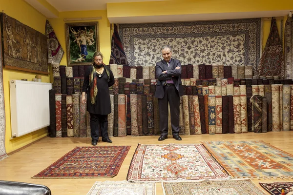 Carpet seller offering colorful oriental carpets at his store