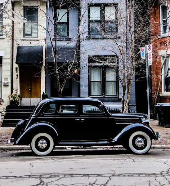 Retro car is next to the house on the street