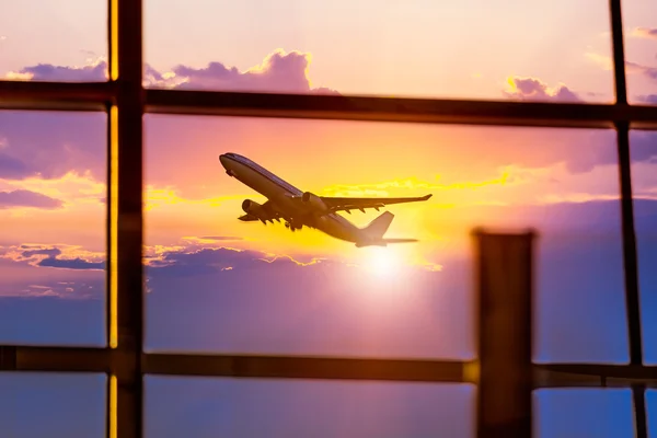 Airport windows and airplane at sunset