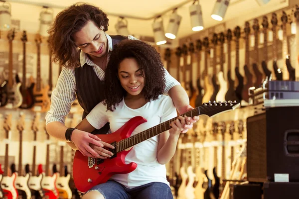 Couple playing electric guitar