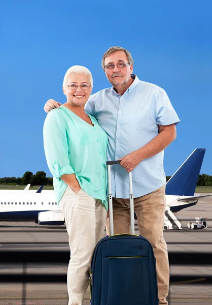Happy senior couple in airport.