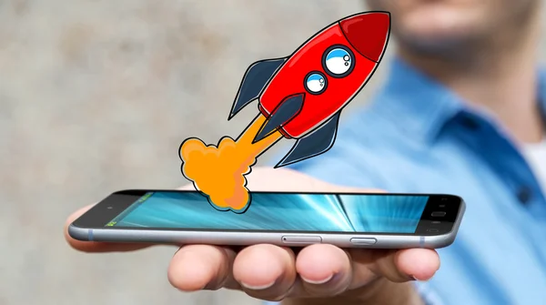 Businessman holding red hand drawn rocket over his mobile phone