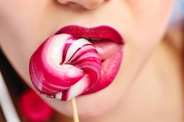 Close-up sexy red lips with lollipop