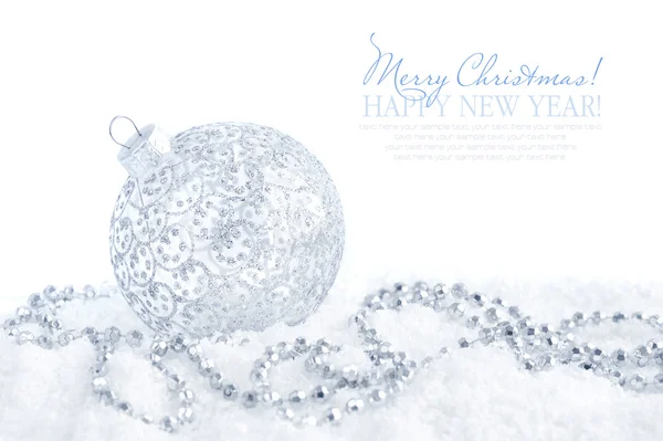 Christmas silver decorations on snow on white background