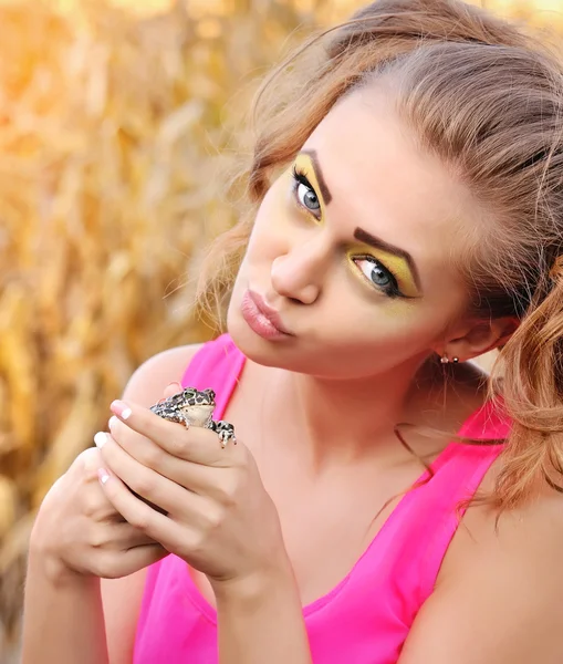 Beautiful young girl holding a cute frog