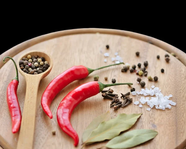 Herbs and spices on wooden board. Chili, salt, pepper, bay leaf,