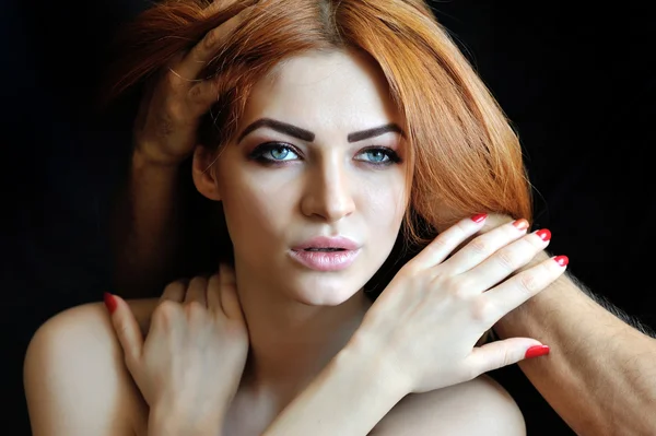 Young sexy redhead woman portrait. Man\'s hands in her hair