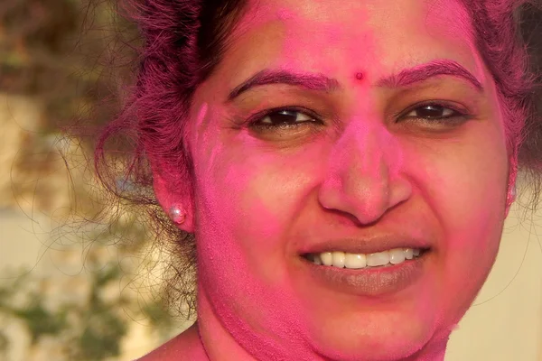 :Portrait of an Indian woman with color powder covered face during celebration Hindu festival holi