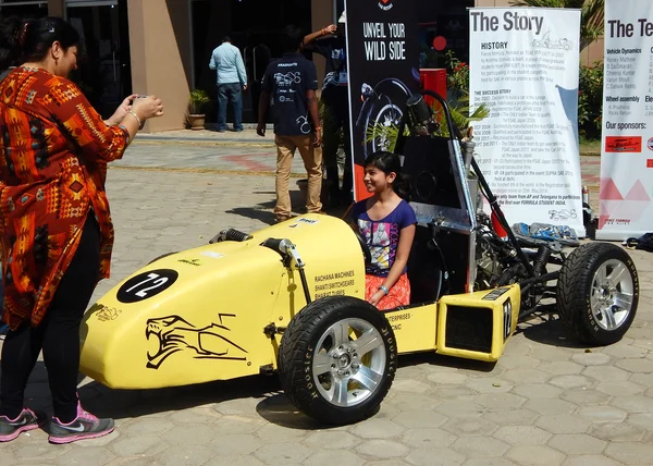 Indian Mother take photo with mobile phone child play with race car model