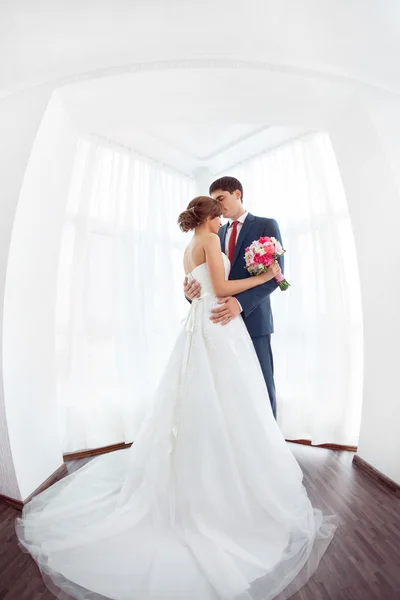 Bride and groom in very bright room at home