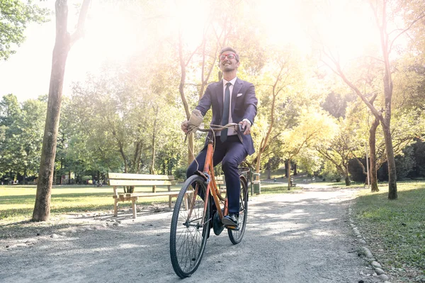 Businessman riding his bike in the park