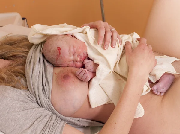 Laying of a newborn baby to the breast after birth