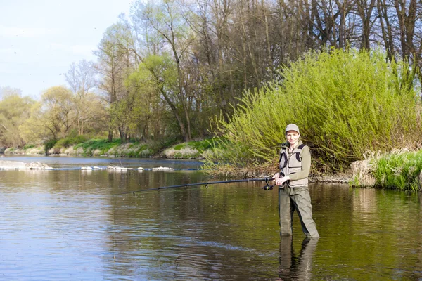 Woman fishing in the river in spring