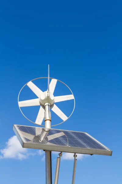 Wind and solar power system against the clear blue sky.