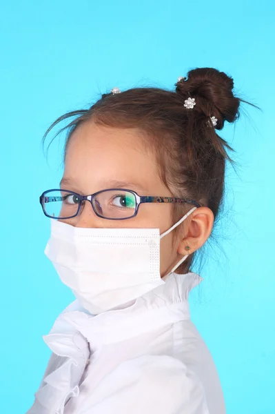 Girl in glasses and a mask playing a doctor