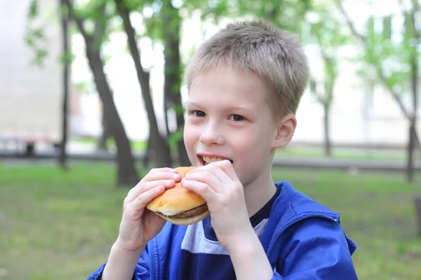 Little boy eating hamburger