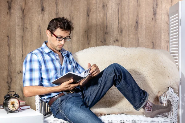 Man relaxing on sofa couch reading novel story book