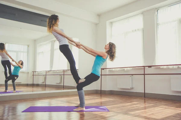 Two fit pretty women are doing balance exercise