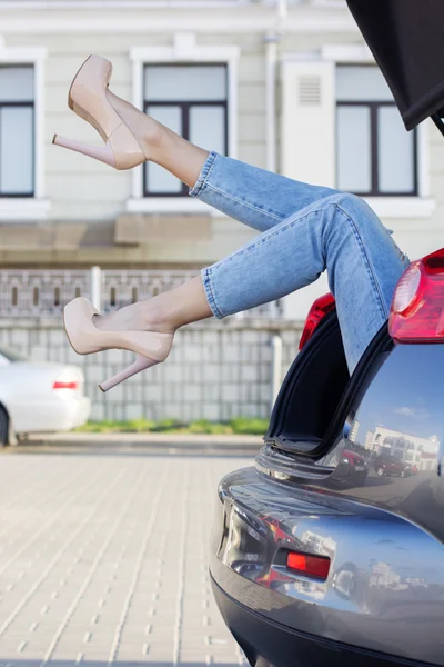 Girls legs in car trunk is wearing fashion heels