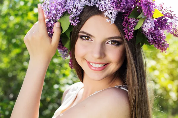 Beautiful girl with wreath of lilac flowers