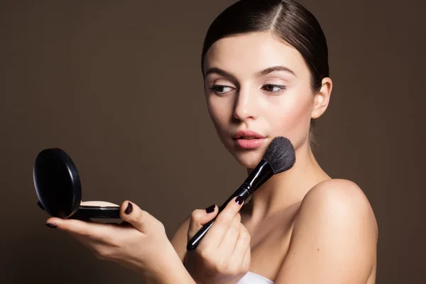 Naturally girl with makeup brush and powder