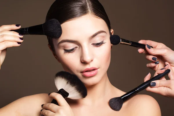 Naturally woman with makeup brushes