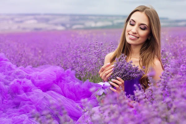 Beautiful smiling woman is wearing fashion dress at lavender