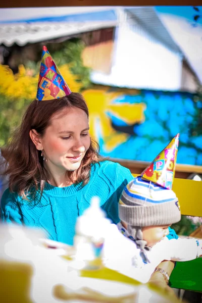 Mom and baby celebrate birthday in sunny day at outdoor