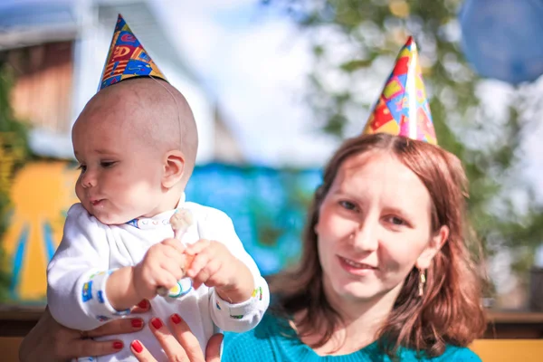 Mom and baby celebrate birthday in sunny day at outdoor