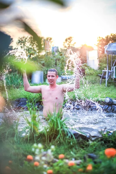 In the summer, bright sunny day, happy man is bathed dives into the pond during sunset