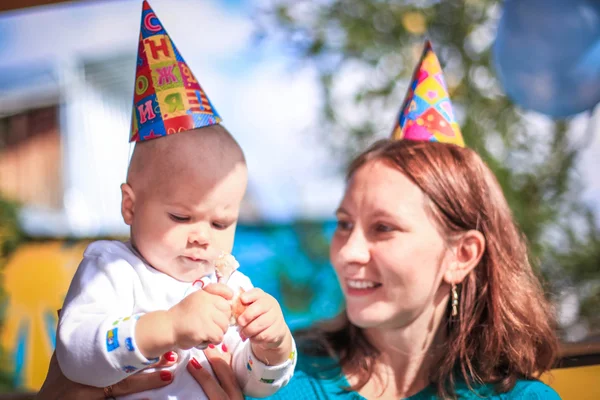 Mom and baby celebrate birthday in sunny day at outdoor