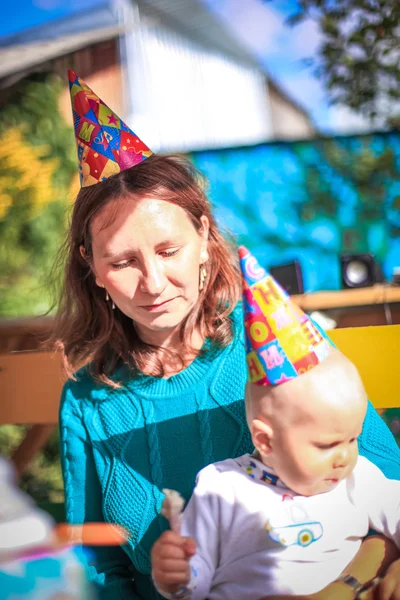 Mom and baby celebrate birthday in sunny day at outdoor