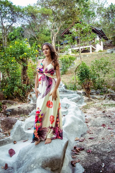 Woman posing at Natural stone stairs leading to house on cliff
