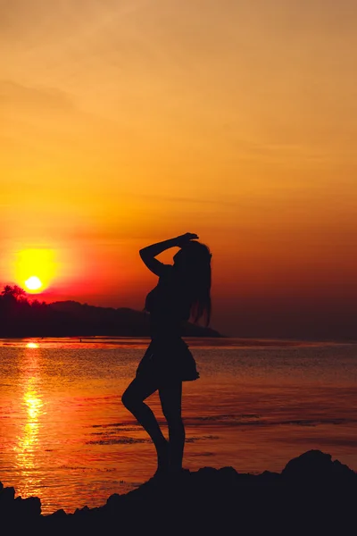 Girl silhouette on sunset beach background