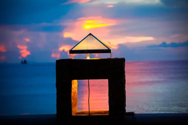 Sunset on seashore of Samui Island, Thailand. water ripples in sea and Stone lantern shines